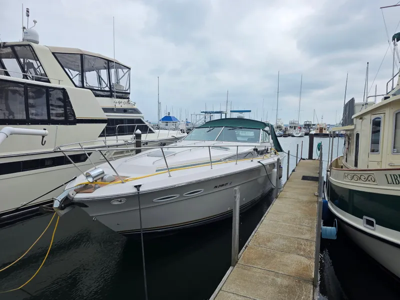 Slide: The Image of 1987 Sea Ray 390 Express Cruiser docked at a marina, surrounded by other boats. - 2