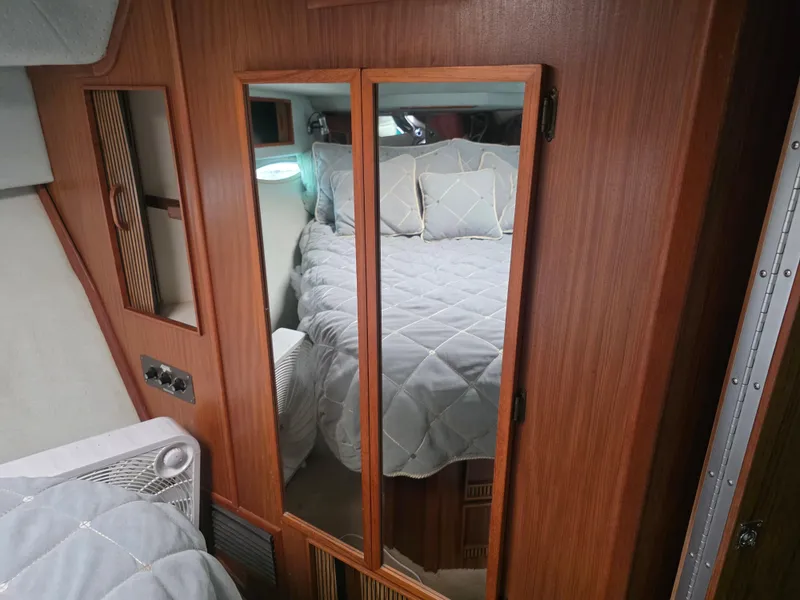Slide: The Image of 1987 Sea Ray 390 Express Cruiser cabin with mirrored closet and cozy bed. - 21