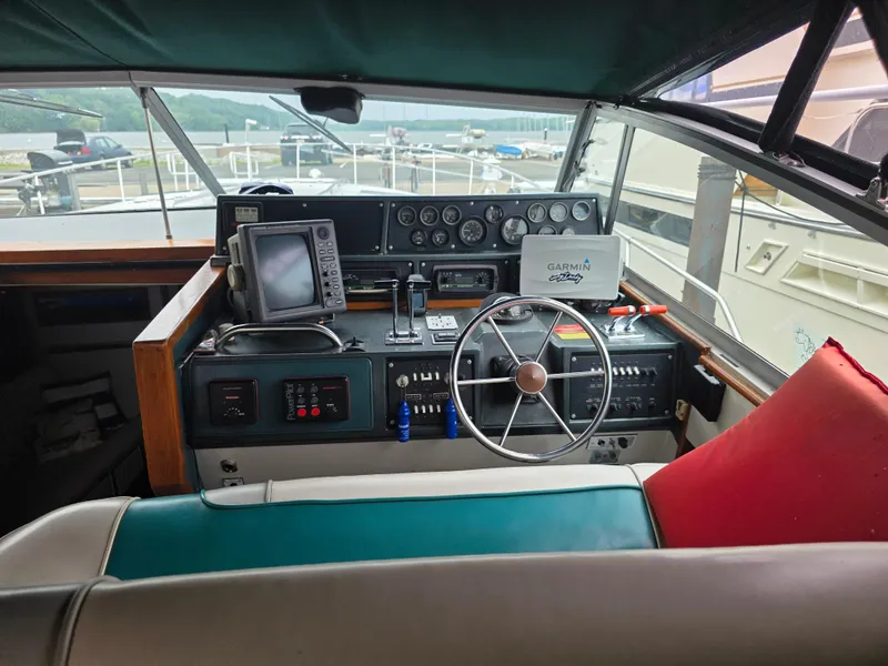 Slide: The Image of 1987 Sea Ray 390 Express Cruiser helm with steering wheel, navigation equipment, and gauges. - 3