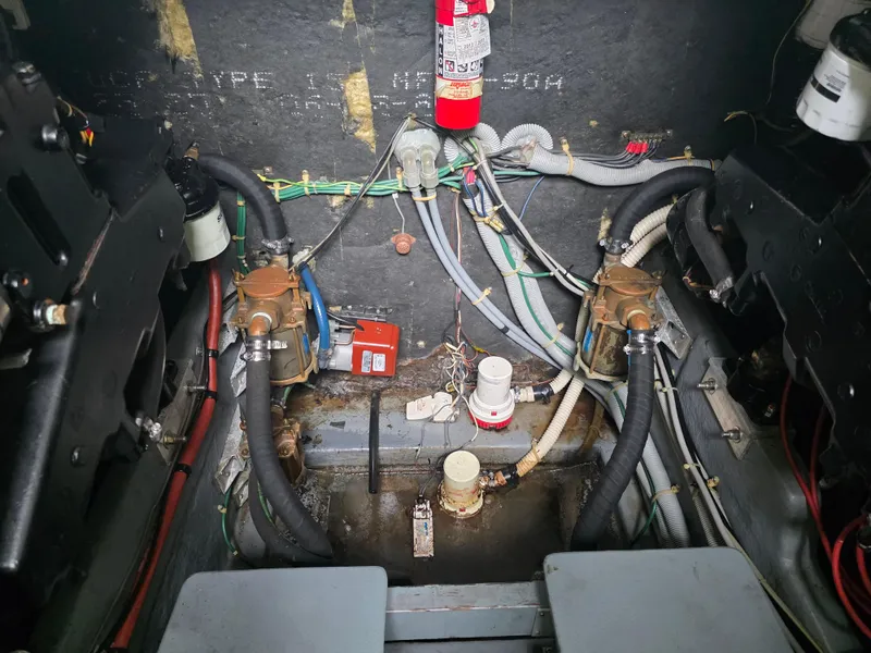 Slide: The Image of Engine compartment of a 1987 Sea Ray 390 Express Cruiser with visible wiring and components. - 31