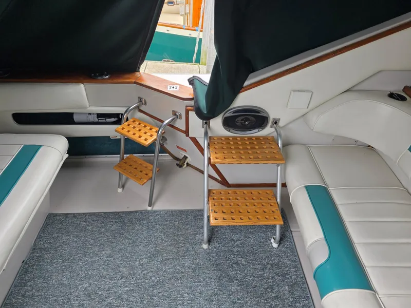 Slide: The Image of Interior of 1987 Sea Ray 390 Express Cruiser with wooden steps and cushioned seating. - 9