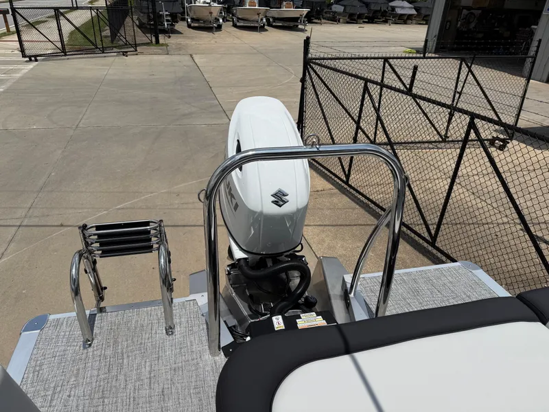 Slide: The Image of 2025 Avalon LSZ Versatile Rear Bench boat with Suzuki outboard motor and ladder. - 35