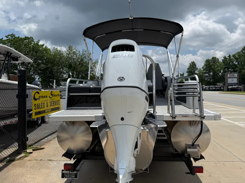 Slide: The Image of 2025 Avalon LSZ Versatile Rear Bench pontoon boat with outboard motor, parked at sales and service center. - 47