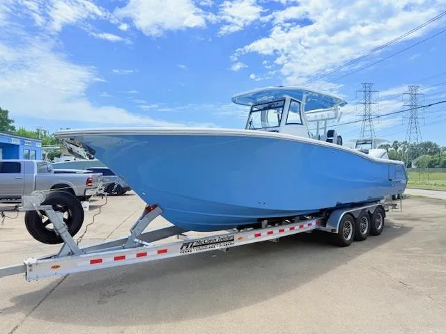 The Image of 2026 Tidewater 302 CC Adventure boat on trailer, blue hull, parked outdoors. - 1