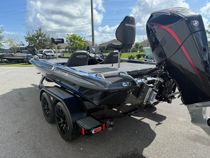 Slide: The Image of 2026 Phoenix 919 ZXL boat with powerful outboard motor, parked on a sunny day. - 15
