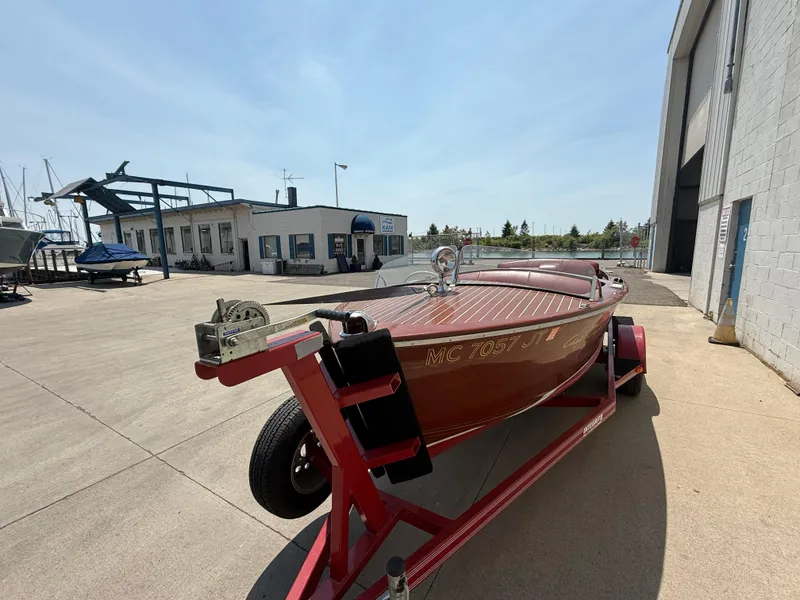 Slide: The Image of 1953 Chris-Craft 17’ Sportsman boat on trailer outside a marina building. - 3