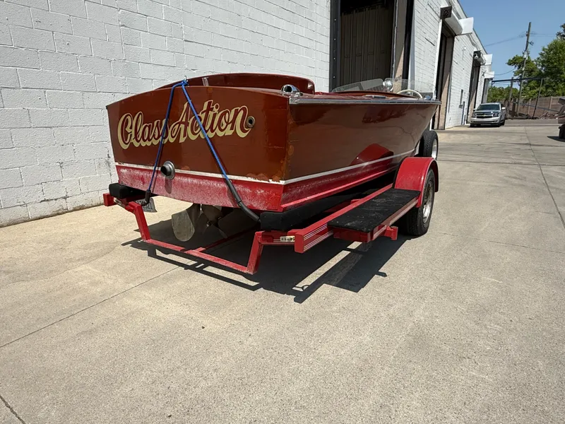 Slide: The Image of 1953 Chris-Craft 17’ Sportsman boat on trailer, parked outside a warehouse. - 9