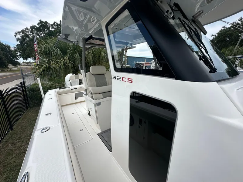 Slide: The Image of 2024 Solace 32 CS boat with open cabin door, near a bridge on the water. - 14