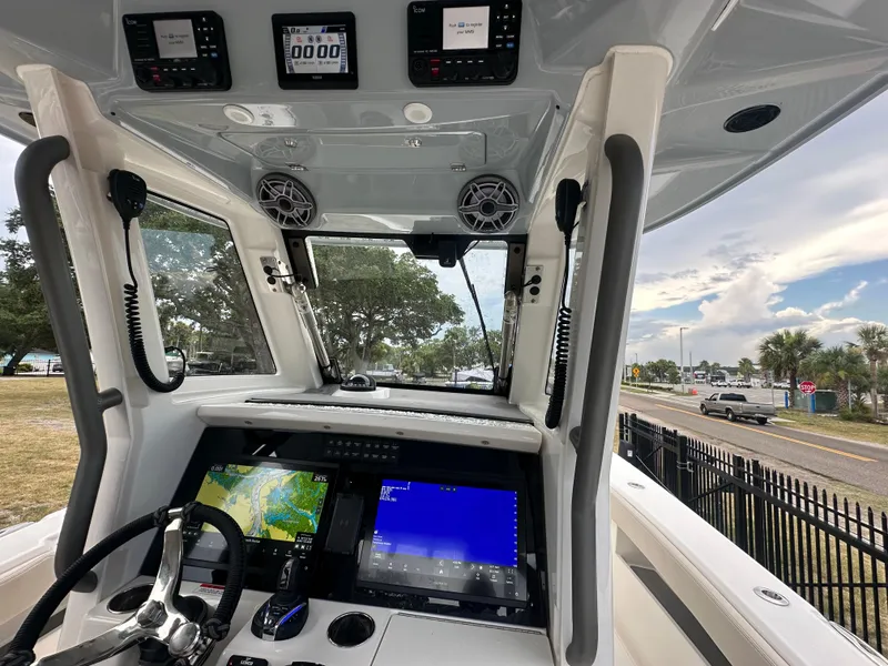 Slide: The Image of 2024 Solace 32 CS boat interior with Yamaha engines, on a sunny day by the water. - 16