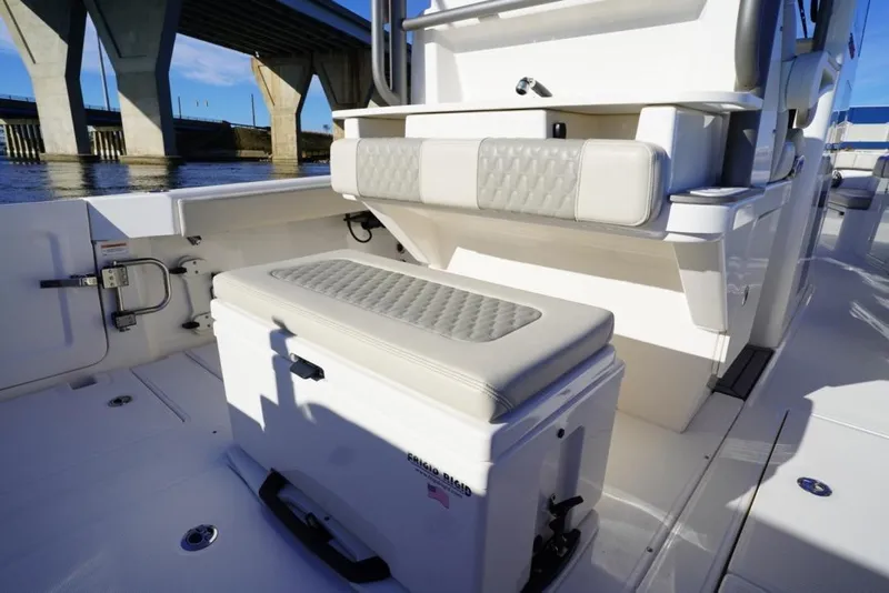 Slide: The Image of 2024 Solace 32 CS boat interior with cushioned seating and storage under a bridge. - 24