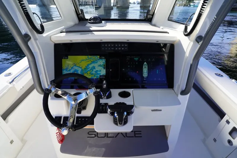 Slide: The Image of 2024 Solace 32 CS boat helm with advanced navigation displays and steering wheel. - 32