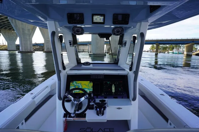 Slide: The Image of 2024 Solace 32 CS boat cockpit with advanced navigation system under a bridge. - 34