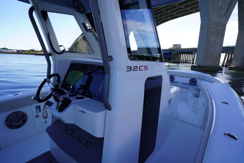 Slide: The Image of 2024 Solace 32 CS boat interior with steering wheel and navigation system. - 35
