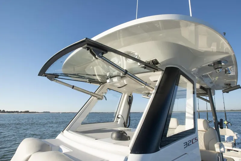 Slide: The Image of 2024 Solace 32 CS boat cruising under a bridge in calm waters. - 5