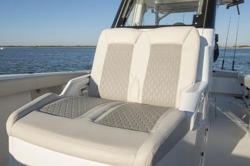 Slide: The Image of 2024 Solace 32 CS boat cruising under a bridge in calm waters. - 6