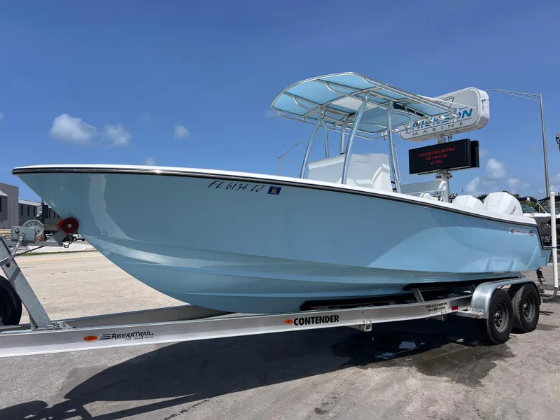 The Image of 2023 Contender 25 Tournament boat on trailer, light blue hull, sunny day. - 0