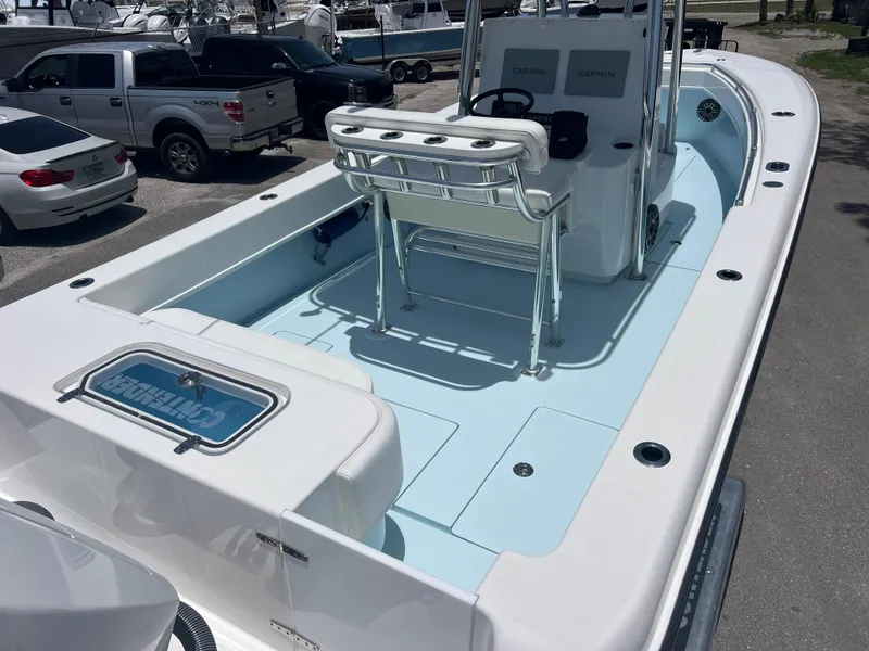 Slide: The Image of 2023 Contender 25 Tournament boat with spacious deck and seating, parked outdoors. - 11