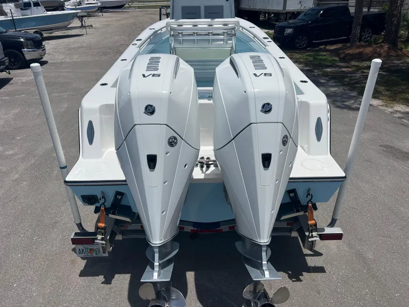 Slide: The Image of 2023 Contender 25 Tournament boat with dual V6 engines, rear view in a parking area. - 4