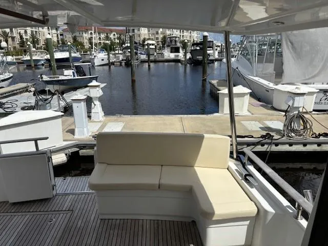 Slide: The Image of 2014 Beneteau Swift Trawler 44 at marina, featuring outdoor seating and dock view. - 13