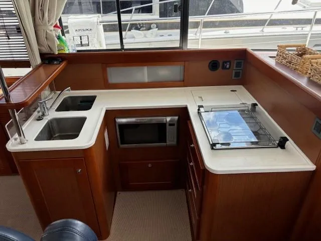 Slide: The Image of 2014 Beneteau Swift Trawler 44 kitchen with sink, stove, and microwave. - 15