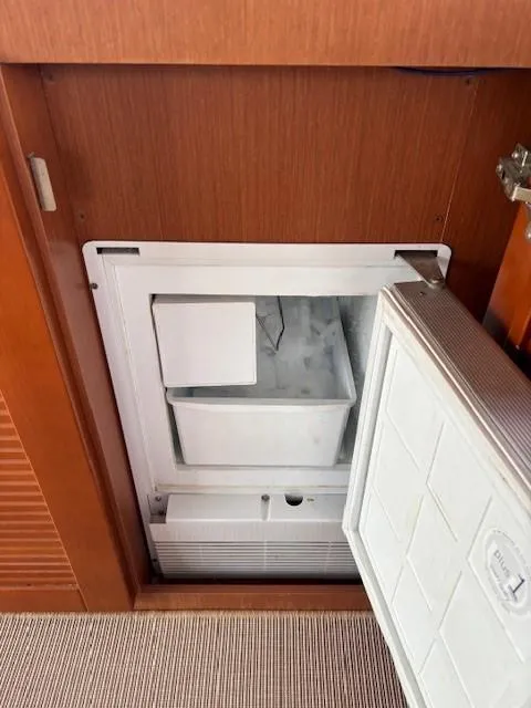 Slide: The Image of Built-in freezer on 2014 Beneteau Swift Trawler 44, open door, wooden interior. - 17