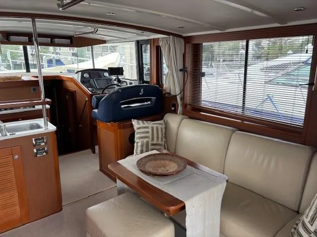 Slide: The Image of Interior of 2014 Beneteau Swift Trawler 44 with beige seating and wooden accents. - 19