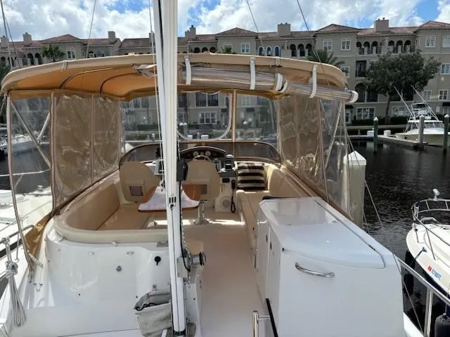 Slide: The Image of 2014 Beneteau Swift Trawler 44 docked, featuring spacious deck and covered seating area. - 2