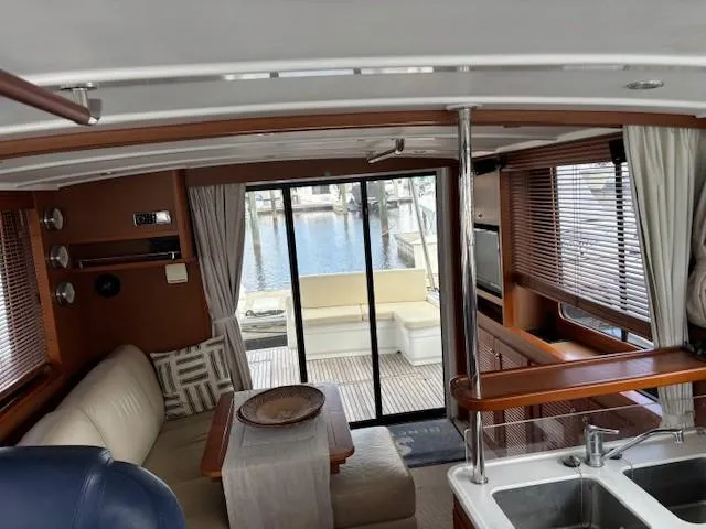 Slide: The Image of Interior of 2014 Beneteau Swift Trawler 44, featuring cozy seating and a view of the marina. - 20