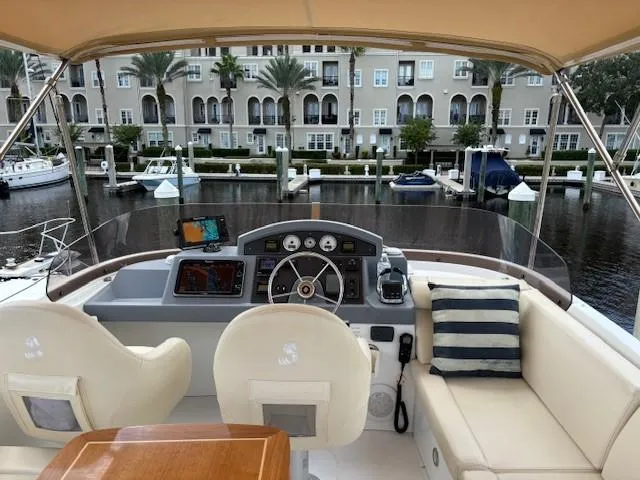 Slide: The Image of 2014 Beneteau Swift Trawler 44 helm with marina view, featuring navigation equipment and seating. - 6