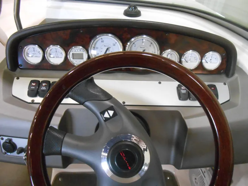 Slide: The Image of Dashboard of a 2006 Regal 2200SLR boat with wood-trimmed steering wheel and gauges. - 5