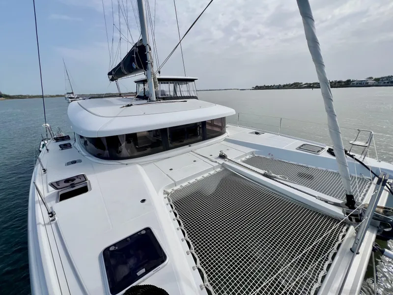 Slide: The Image of 2024 Lagoon 42 catamaran on calm water, featuring sleek design and spacious deck. - 11