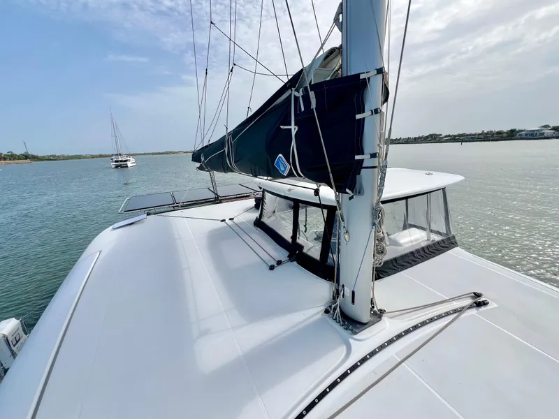 Slide: The Image of 2024 Lagoon 42 catamaran sailing on calm waters under a cloudy sky. - 16