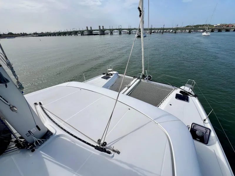 Slide: The Image of 2024 Lagoon 42 catamaran on calm water near a bridge. - 20