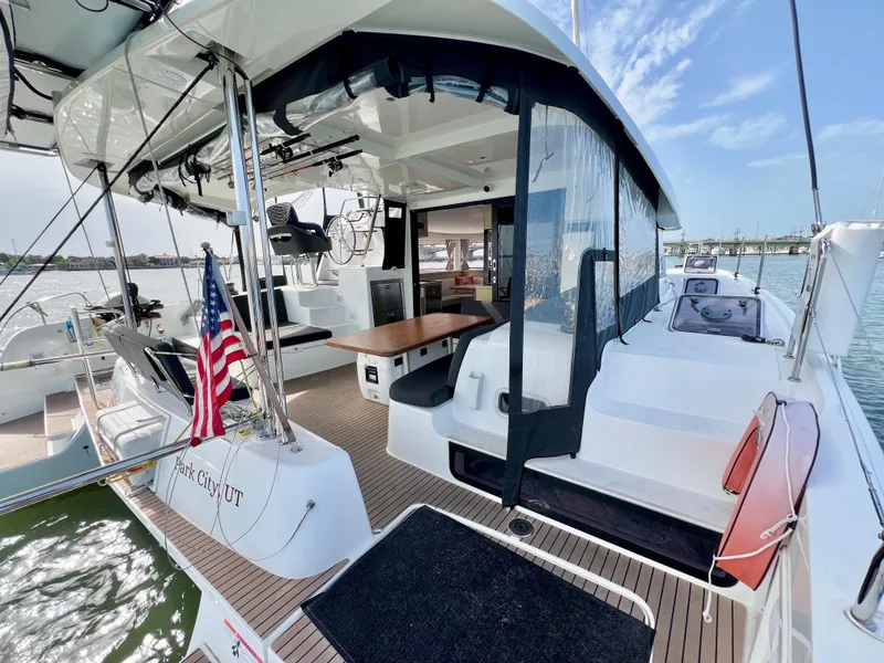 Slide: The Image of 2024 Lagoon 42 catamaran with spacious deck, modern design, and American flag. - 22