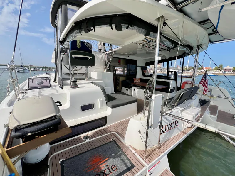 Slide: The Image of 2024 Lagoon 42 catamaran with spacious deck and modern amenities, docked at a marina. - 23