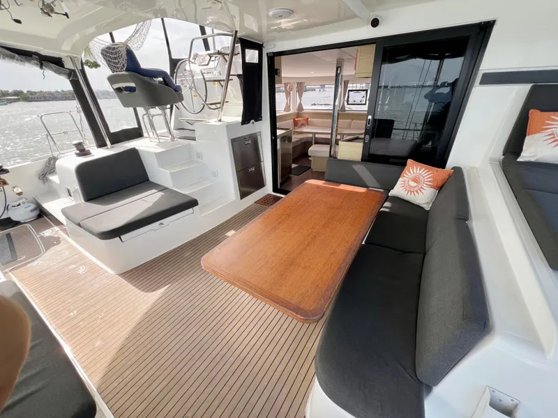 Slide: The Image of 2024 Lagoon 42 yacht interior with spacious seating and wooden table. - 25