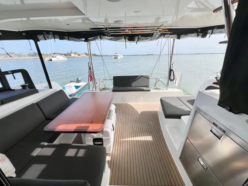 Slide: The Image of 2024 Lagoon 42 catamaran interior with seating, table, and ocean view. - 26