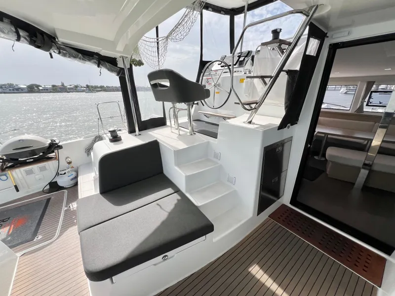 Slide: The Image of 2024 Lagoon 42 yacht cockpit with seating, helm, and water view. - 27