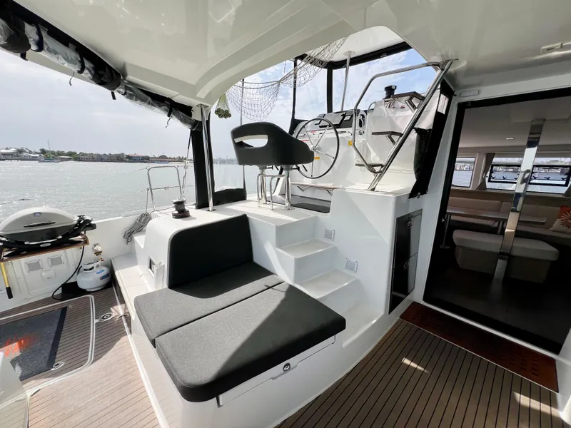 Slide: The Image of 2024 Lagoon 42 yacht cockpit with seating, helm, and view of the water. - 31