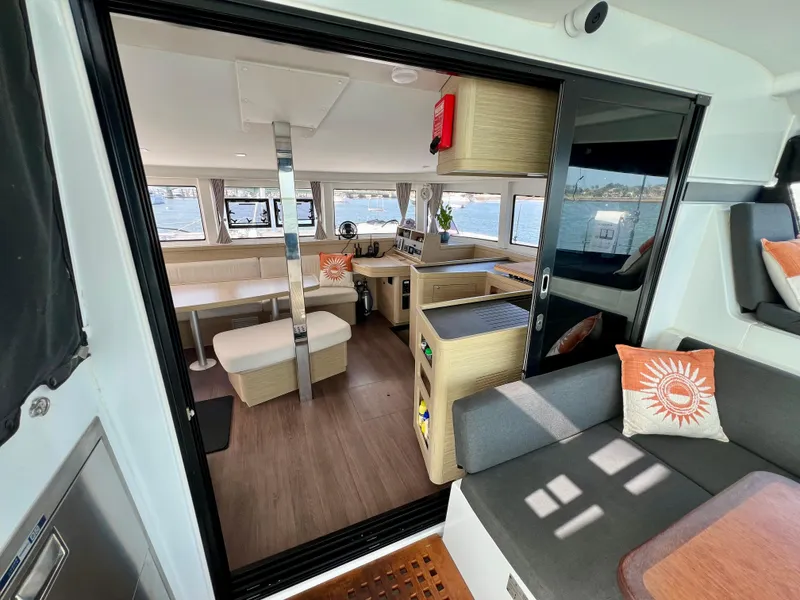 Slide: The Image of 2024 Lagoon 42 yacht interior with modern seating, dining area, and panoramic windows. - 34