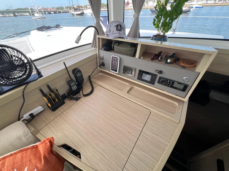 Slide: The Image of 2024 Lagoon 42 yacht interior with navigation station, gadgets, and sea view. - 44