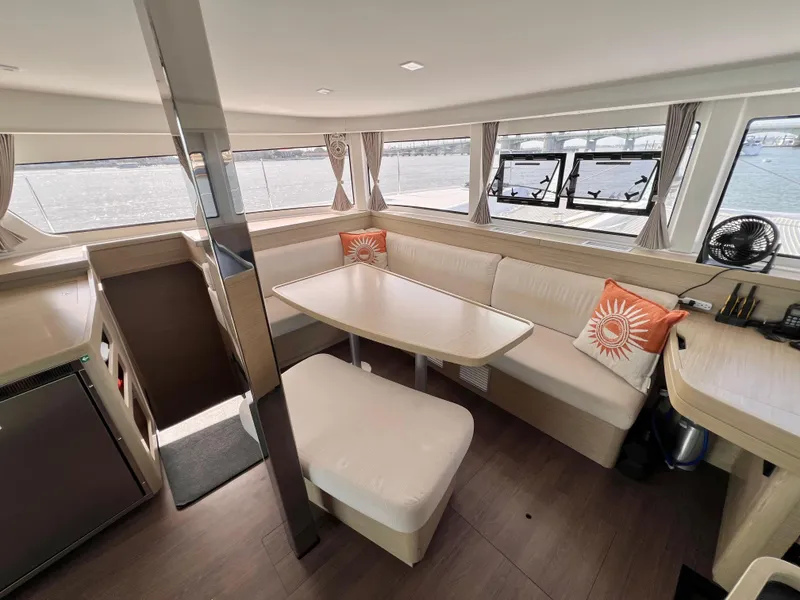 Slide: The Image of 2024 Lagoon 42 catamaran interior with modern seating and panoramic windows. - 49