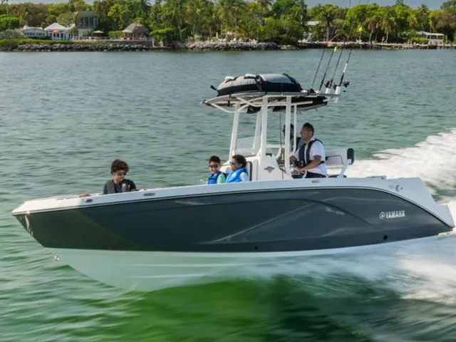 The Image of 2025 Yamaha Boats 222 FSH Sport cruising on a scenic waterway with passengers. - 0