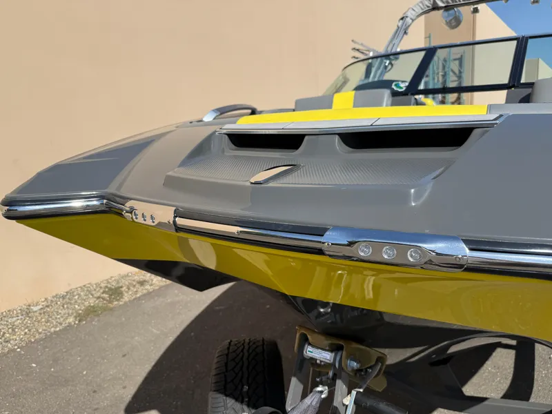 Slide: The Image of 2019 MasterCraft X22 boat, close-up of sleek yellow and gray hull design. - 11
