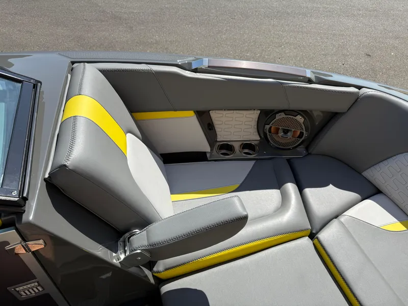 Slide: The Image of 2019 MasterCraft X22 boat interior with gray and yellow seating, speaker, and armrest. - 27
