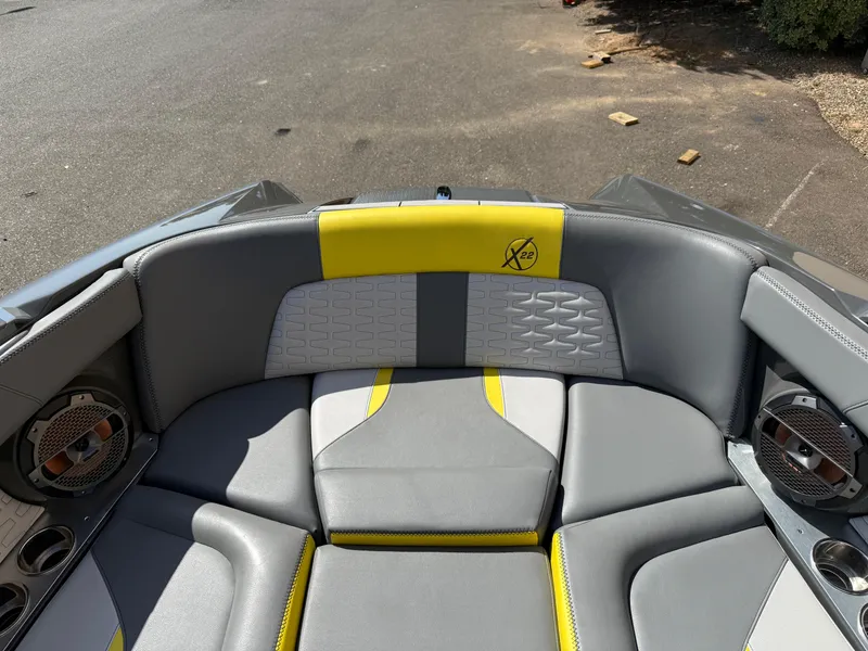 Slide: The Image of 2019 MasterCraft X22 boat interior with gray and yellow seating, featuring premium speakers. - 28