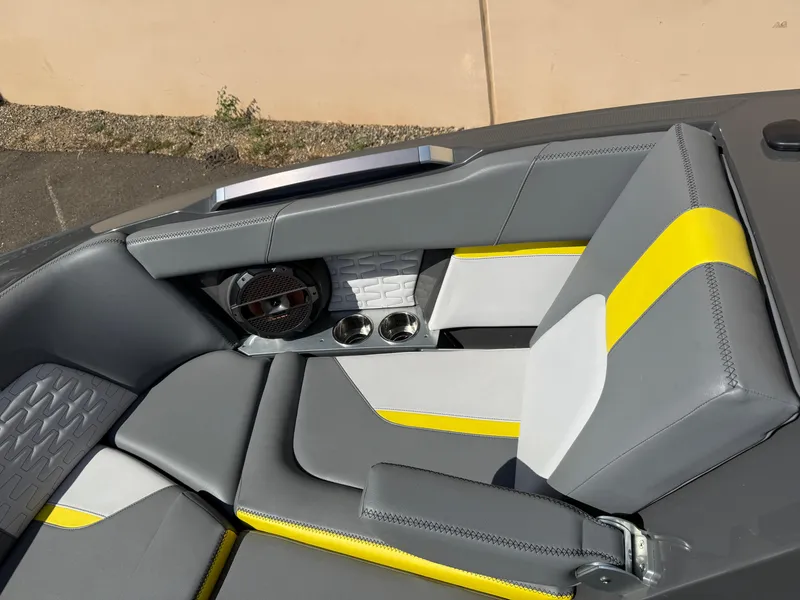 Slide: The Image of 2019 MasterCraft X22 boat interior with gray and yellow seating, cup holders, and speaker. - 29