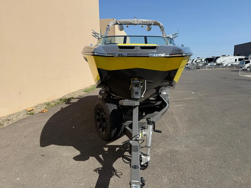 Slide: The Image of 2019 MasterCraft X22 boat on trailer, yellow and black, parked outdoors. - 6