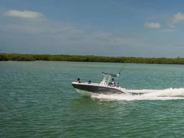 Slide: The Image of 2025 Yamaha Boats 222 FSH Sport cruising on a serene lake under a clear sky. - 4