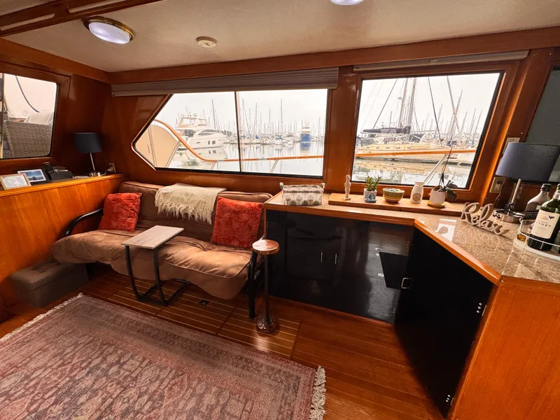 Slide: The Image of Luxurious 1988 Overseas PT52 yacht interior with cozy seating, large windows, and elegant decor. - 2